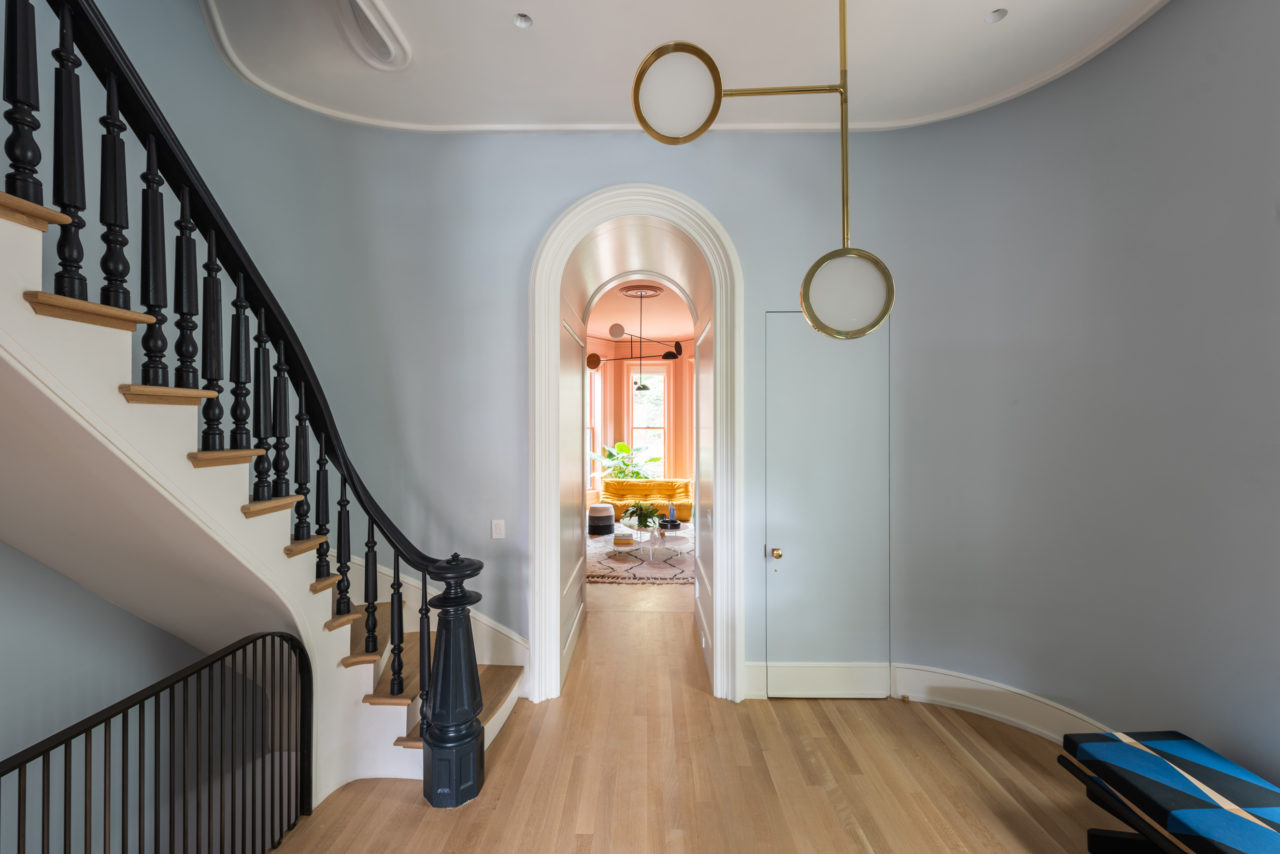 stair hall with light pastel blue wall paint with modern lighting wood flooring