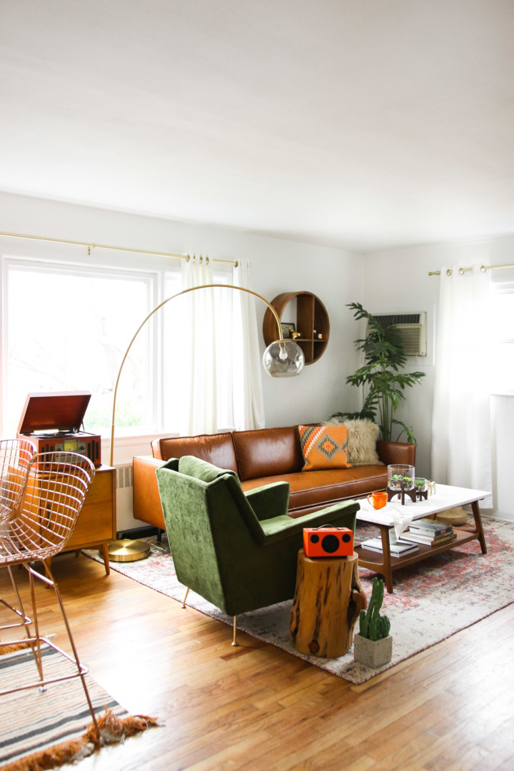 small mid century modern living room with brown leather sofa and green armchair