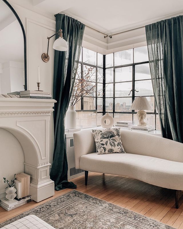 window reading nook with white chaise lounge dark curtains and faux fireplace