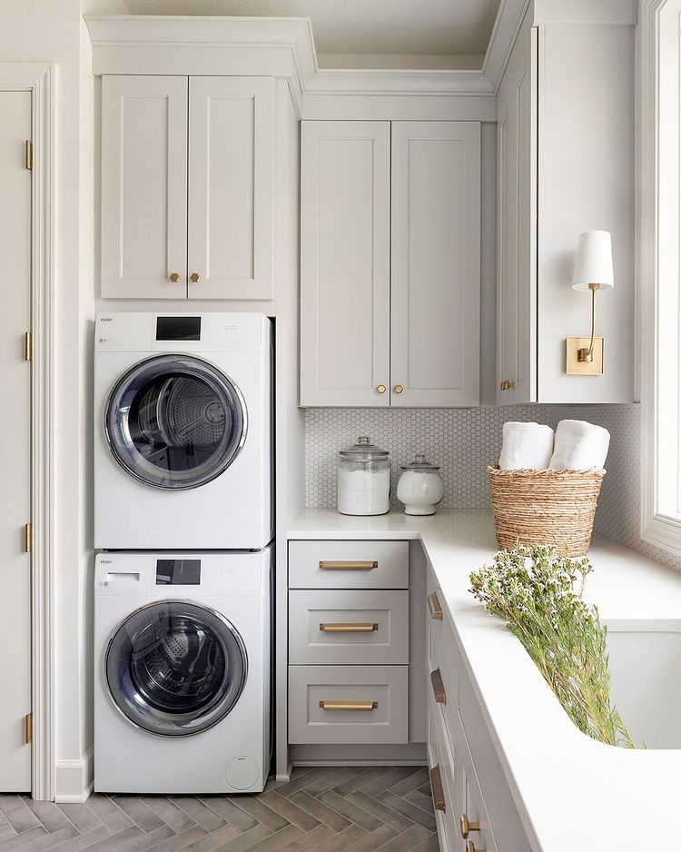 laundry room with brass hardware and warm gray cabinets