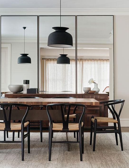 contemporary dining room with 3 large vertical decorative mirrors on the wall