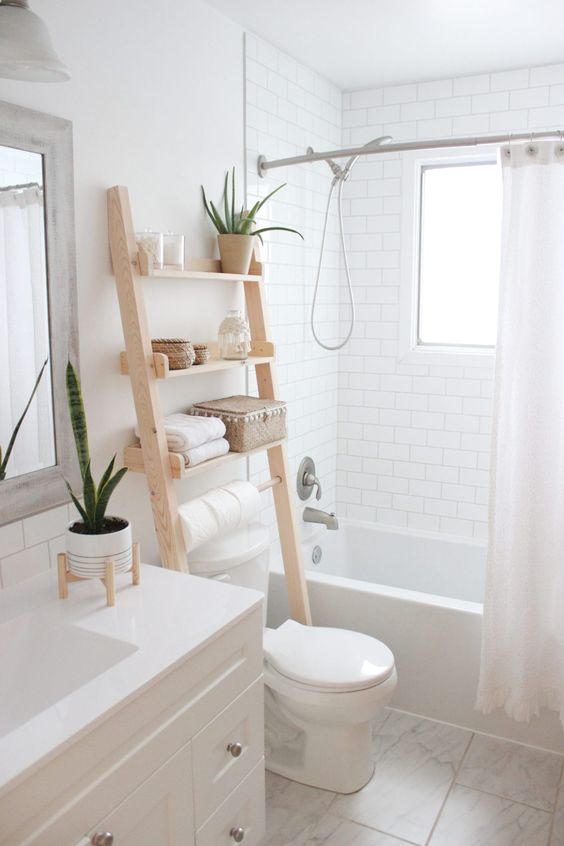 bathroom with over the toilet wood ladder shelves