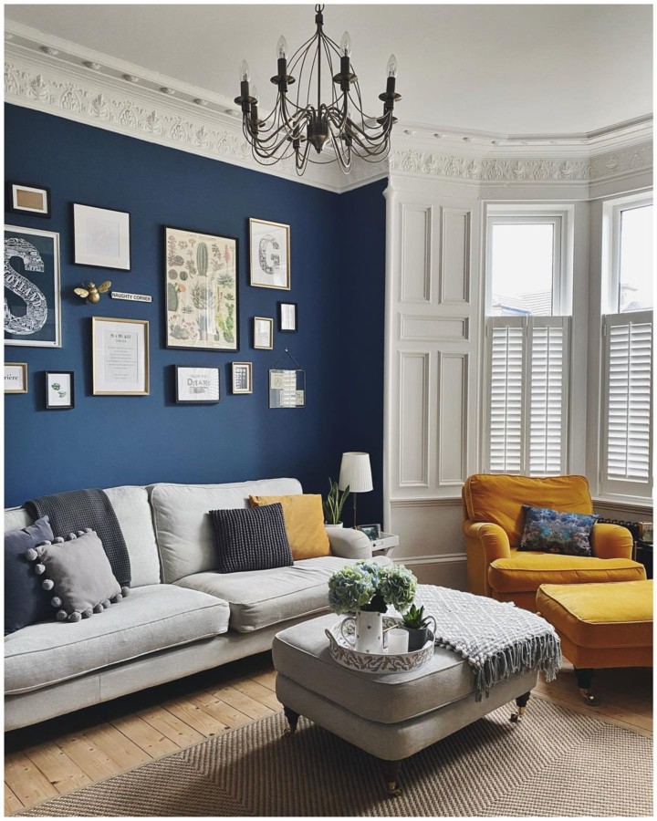 cozy living room with dark blue accent wall and art gallery