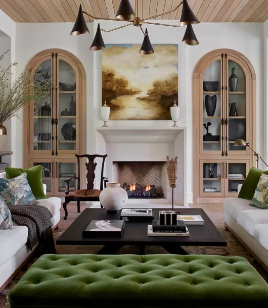neutral living room with green velvet tufted ottoman and pillows