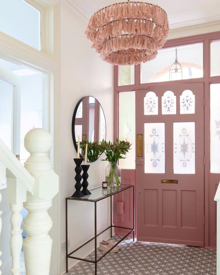 hallway with pink front door pink chandelier and reto black and white flooring 