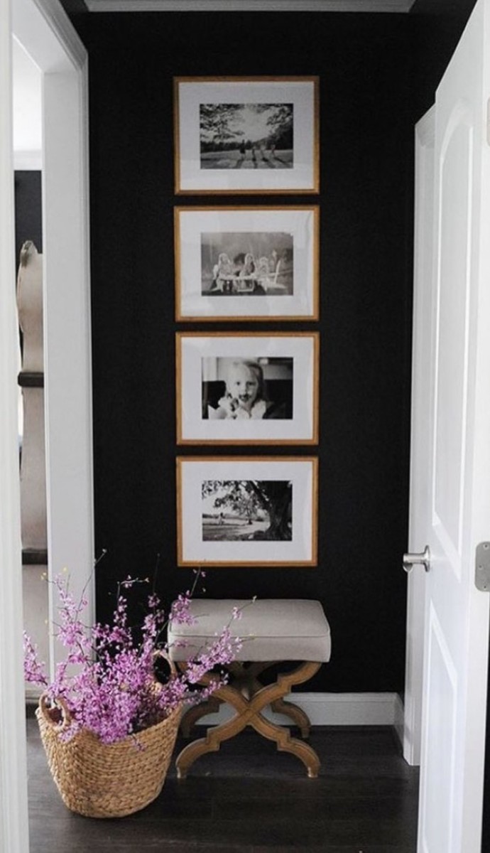 black wall with framed black and white family photos