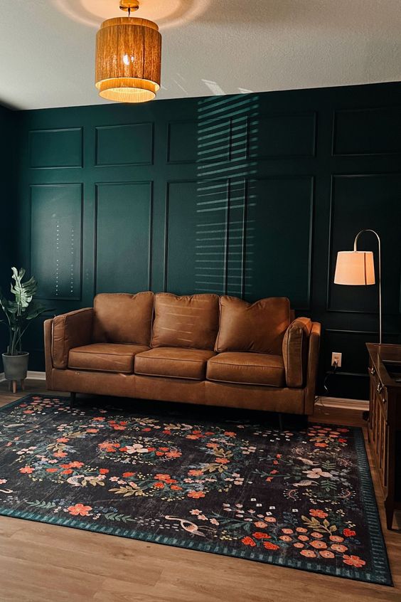brown leather sofa with emerald wall