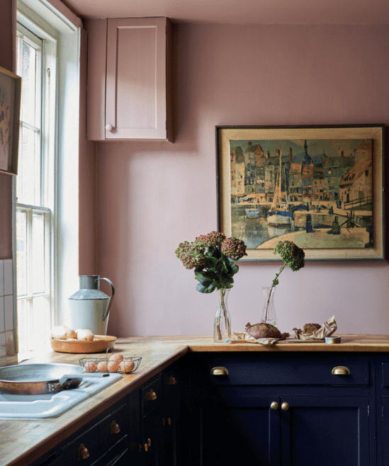 kitchen with blush pink walls and dark blue navy cabinets