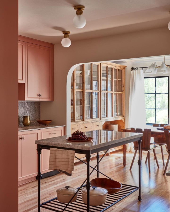 Soothing pink kitchen with marble counters and wooden floors