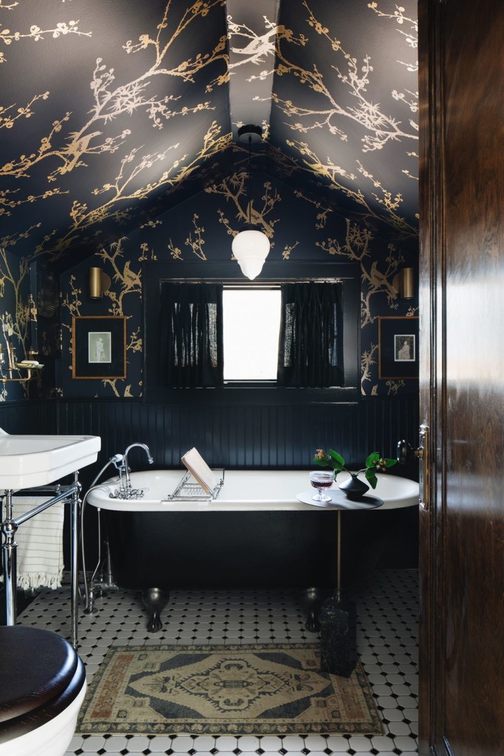 Black wood paneling is paired with a dark wallpaper in the bathroom
