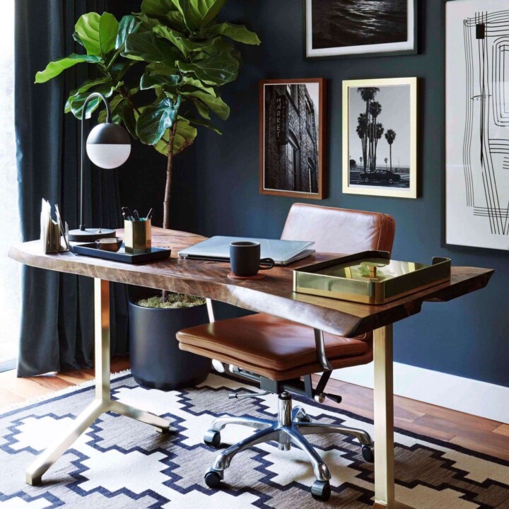 modern mid-century home office with black wall and leather brown office chair