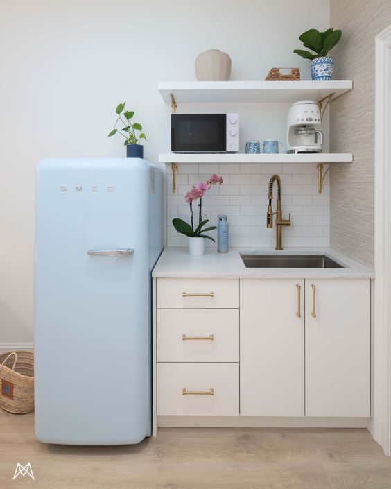 small white office kitchenette with small light blue smeg refrigator