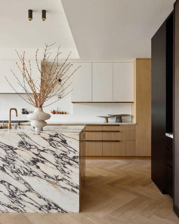 modern white kitchen with Herringbone wood flooring pattern and calacatta marble kitchen island