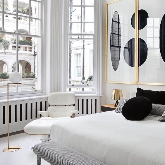Parisian modern blaxk and wite bedroom with oversized modern wall art with gold frames
