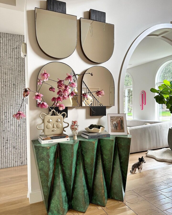 entrance with vintage mirror adorns a sleek modern green console table