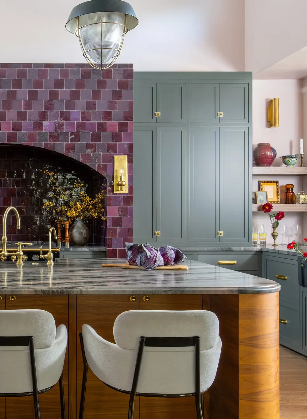 Kitchen with plum tile backsplash, gray cabinetry, marble countertops, and brass accents, blending bold color with traditional craftsmanship.