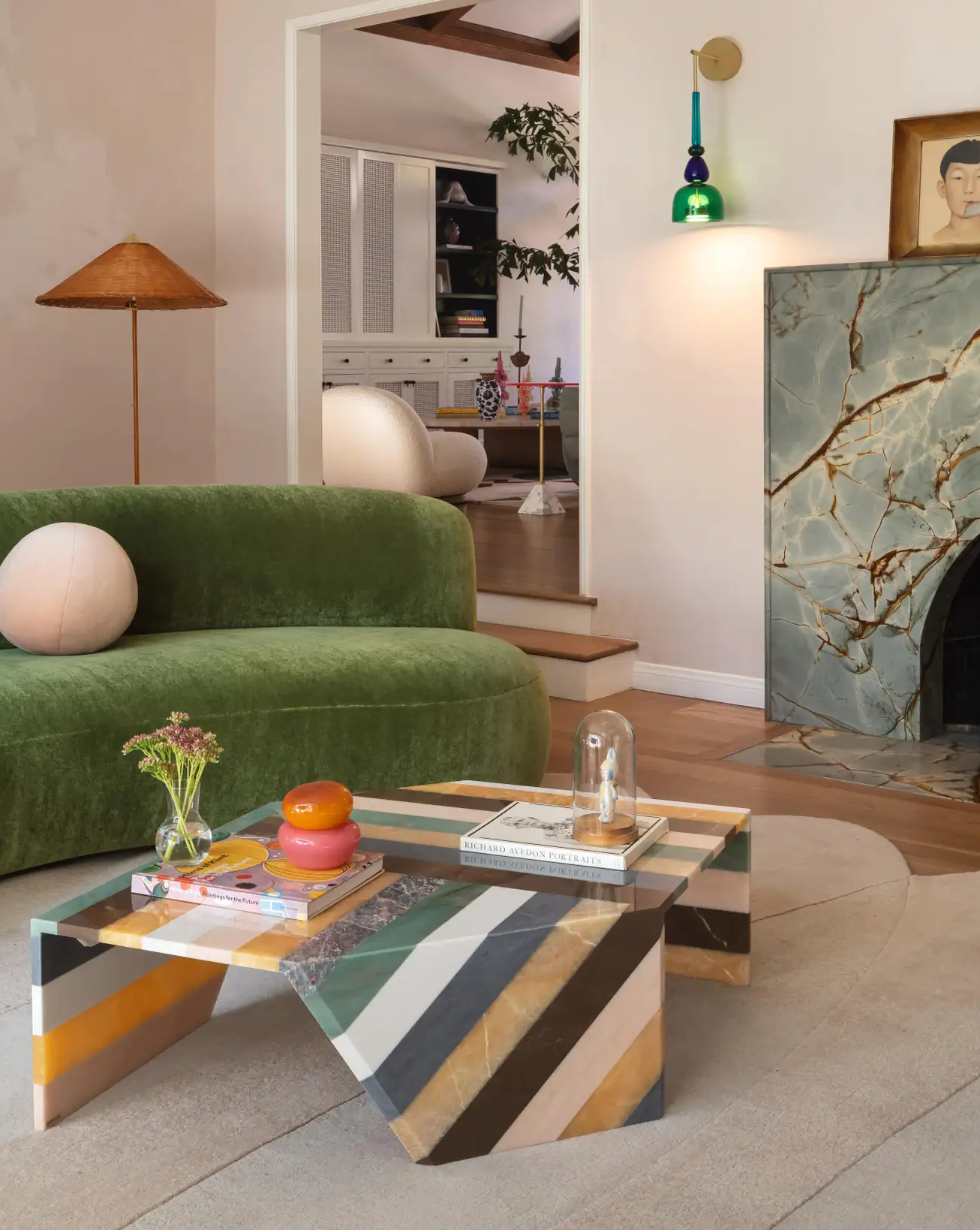 Curved green velvet sofa and marble fireplace in a bright Hollywood Hills living room