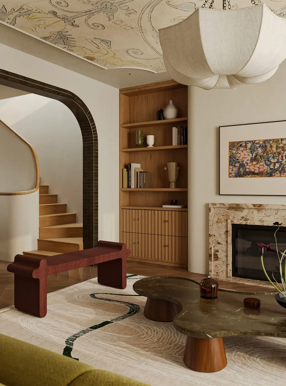 An elegant, artfully layered living room blending contemporary organic design with Mediterranean and Art Deco influences. The space features warm wood built-ins, sculptural furniture, and softly curved architectural details, including a dramatic dark arched doorway leading to a staircase. A large cloud-like fabric pendant light hangs beneath a hand-painted decorative ceiling mural, adding a sense of craftsmanship and old-world character. The room is styled with rich natural textures, a marble fireplace surround, abstract wooden bench seating, and a sculptural coffee table in dark stone and wood. Earthy tones, curated ceramics, and refined materials create a warm, sophisticated atmosphere that feels both timeless and modern.