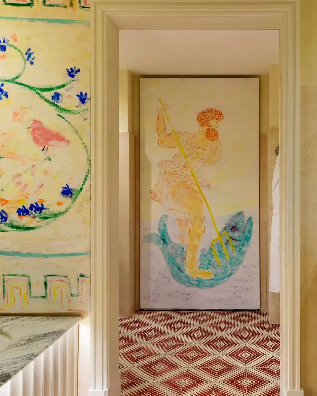 Hallway inside the Michael McGregor Art Suite at Casa Monti Rome featuring large pastel-style mythological murals, patterned terracotta floor tiles, and whimsical hand-drawn artwork inspired by classical antiquity.