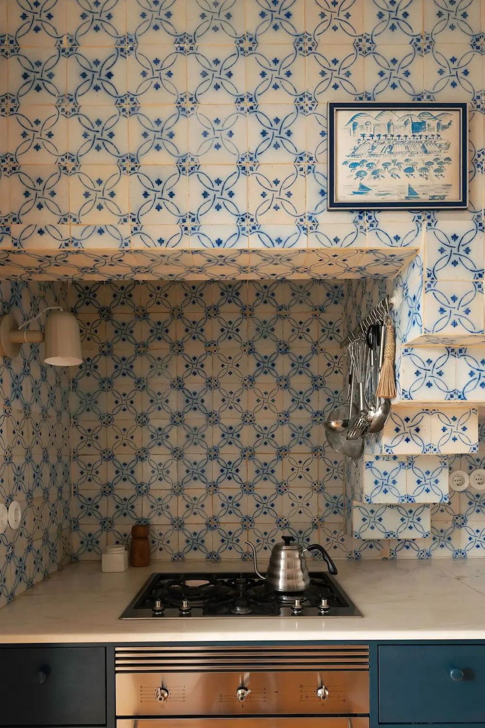 Close-up of a Portuguese kitchen with vintage blue-and-white tile walls, a marble countertop, stainless steel range, and handcrafted details that celebrate traditional Lisbon design.