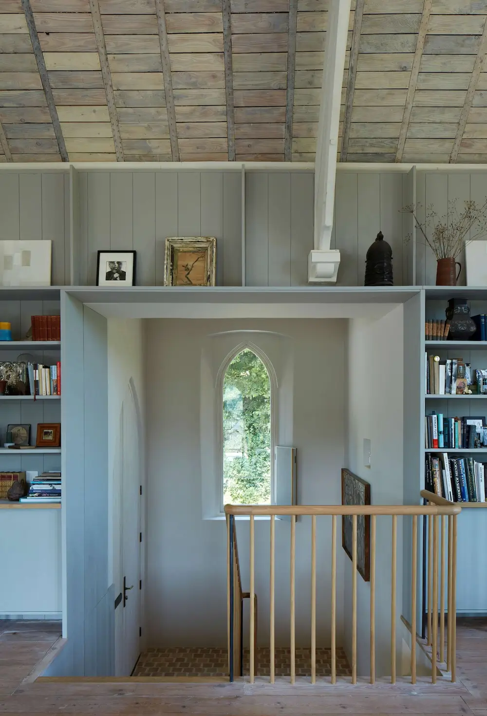Built-in bookshelves and mezzanine landing inside The Old Chapel by Tuckey Design Studio.
