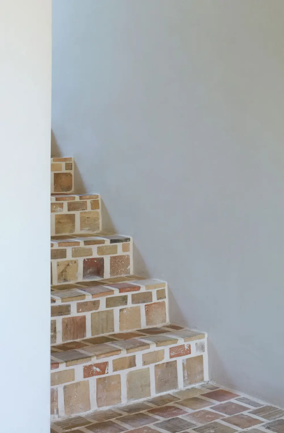 Reclaimed terracotta-tiled staircase inside the renovated Old Chapel in Devon.