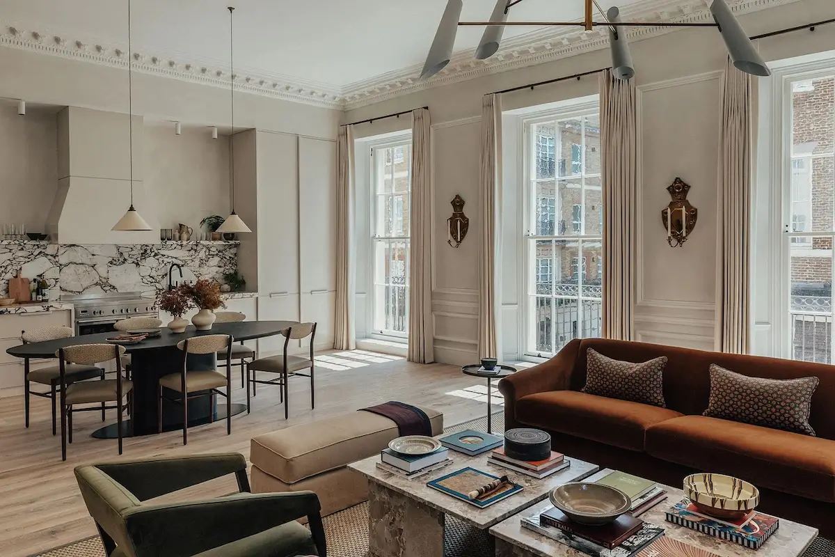 Open-plan living and dining room with marble kitchen, velvet sofa, and period details in A.LONDON's Mayfair residence.