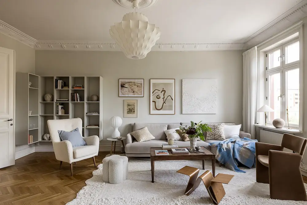 Scandinavian living room featuring neutral decor, modern artwork, and natural wood furniture.