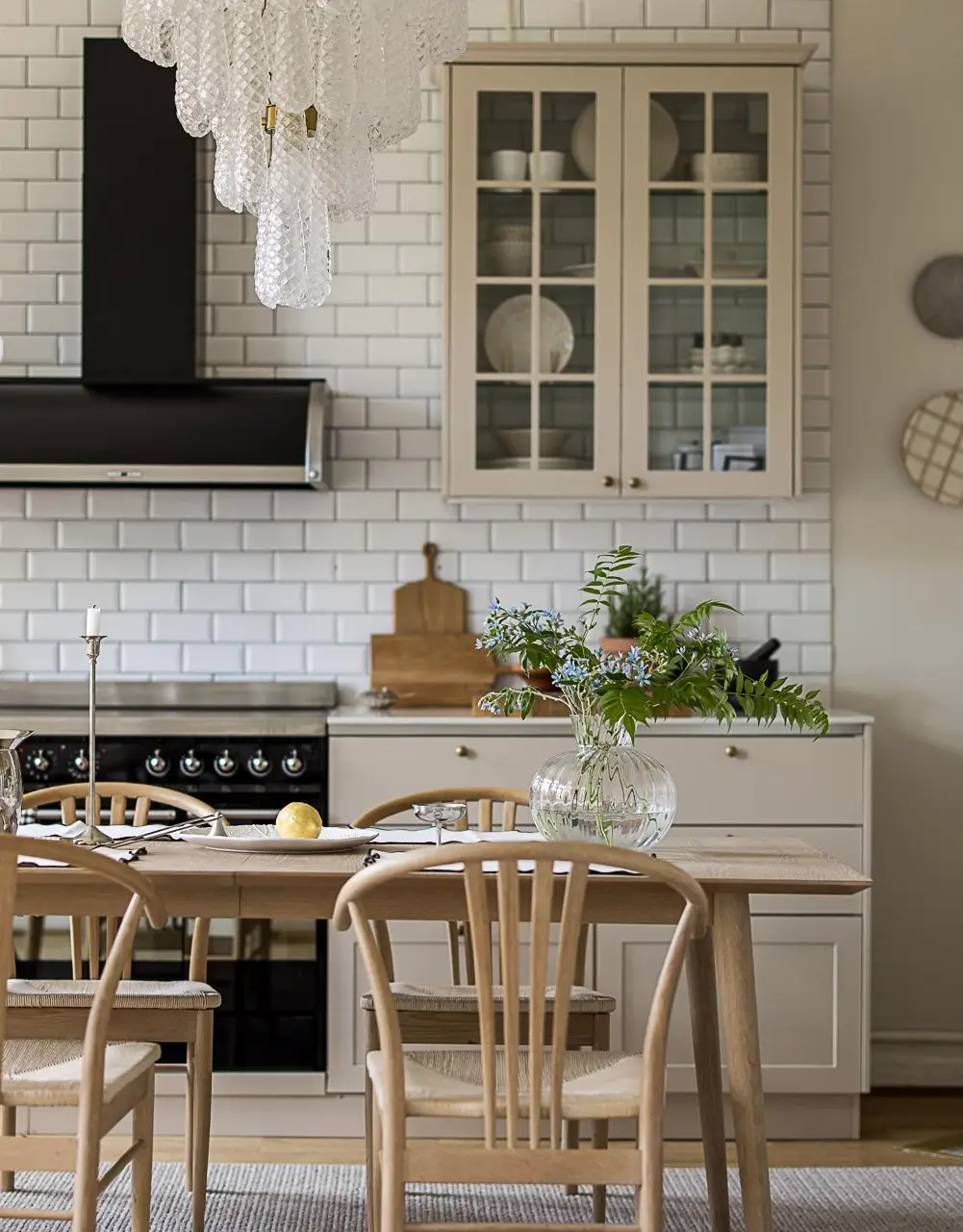 Cream kitchen cabinets with glass-front doors and white subway tile backsplash.
