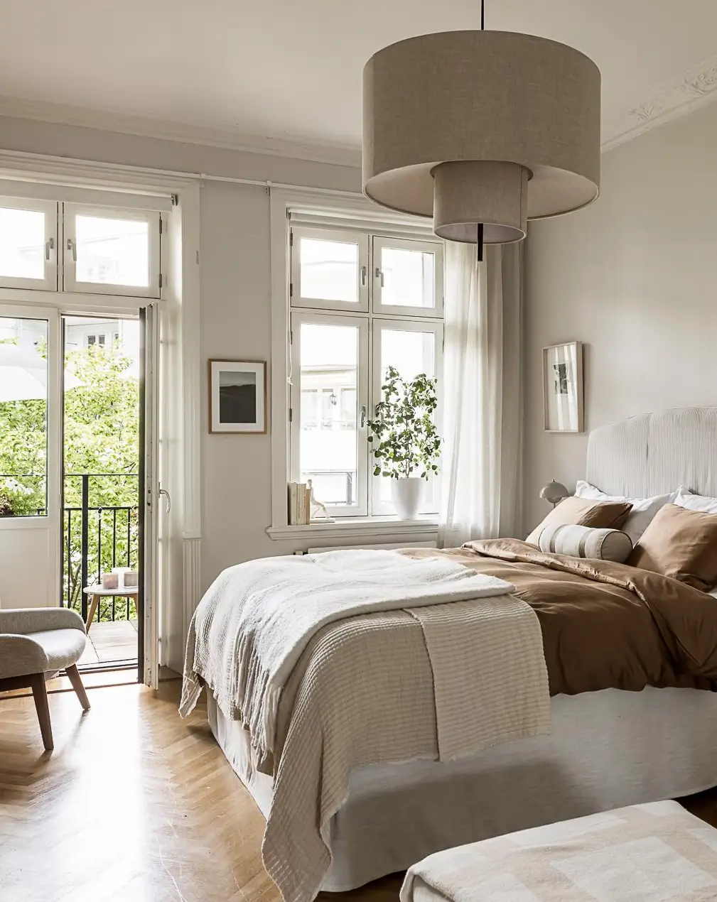 Serene Scandinavian bedroom with neutral bedding, balcony doors, and abundant natural light.